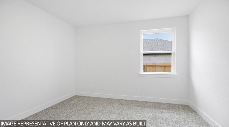 Secondary bedroom with carpet flooring and bright window.
