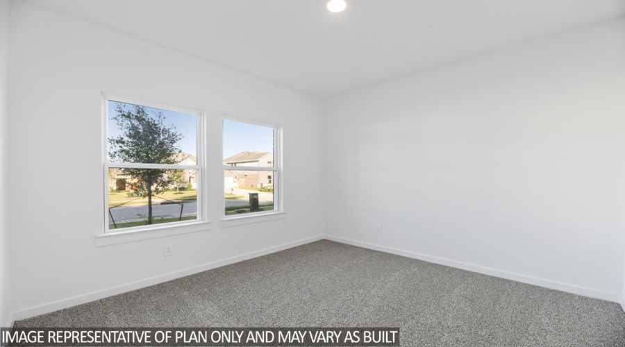 Secondary bedroom with carpet flooring and bright windows.