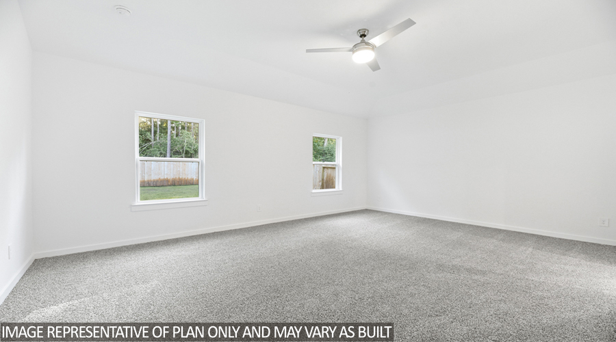 Primary bedroom with carpet flooring and bright windows.
