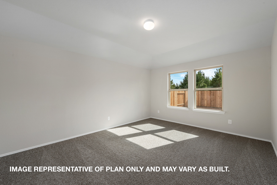 Primary bedroom with carpet flooring and bright windows.
