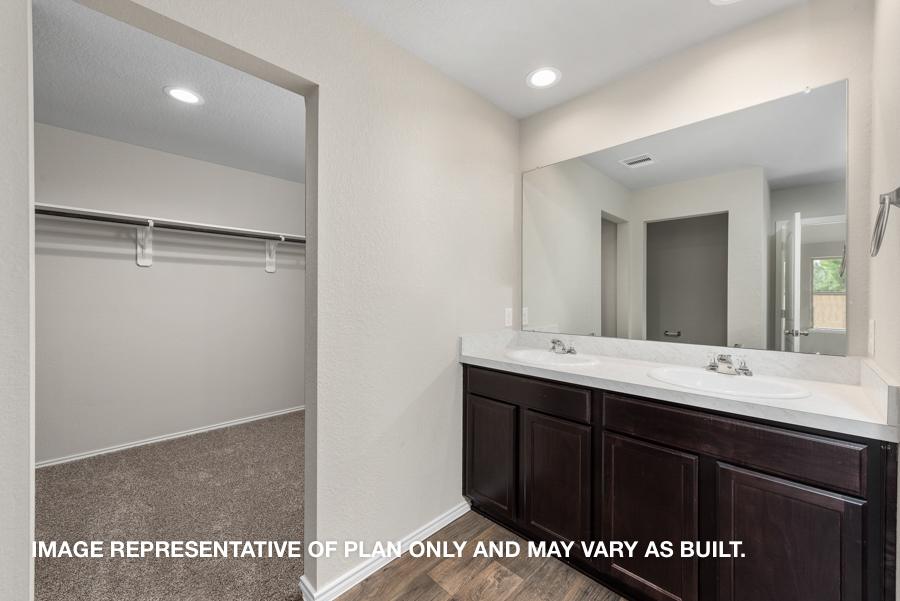 Primary bathroom with double sink and walk-in closet.