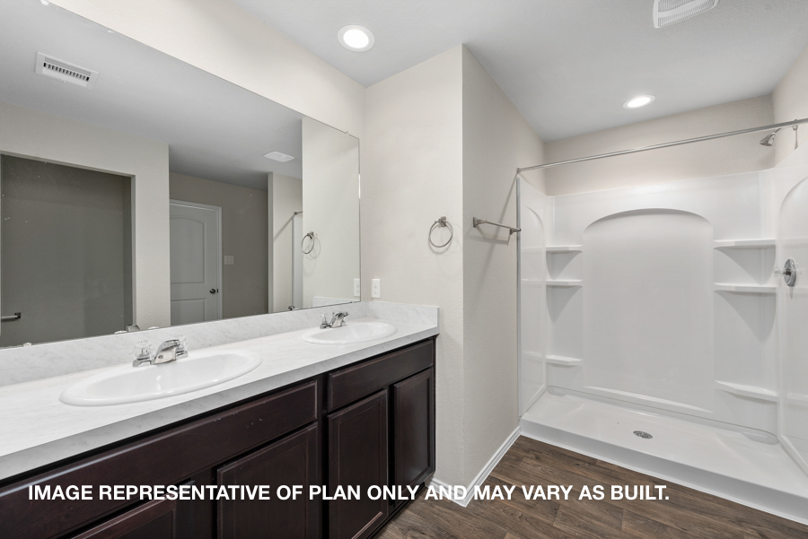 Primary bathroom with double sink and standing shower.