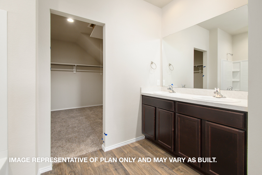 Primary bathroom with double sink and spacious walk-in closet.