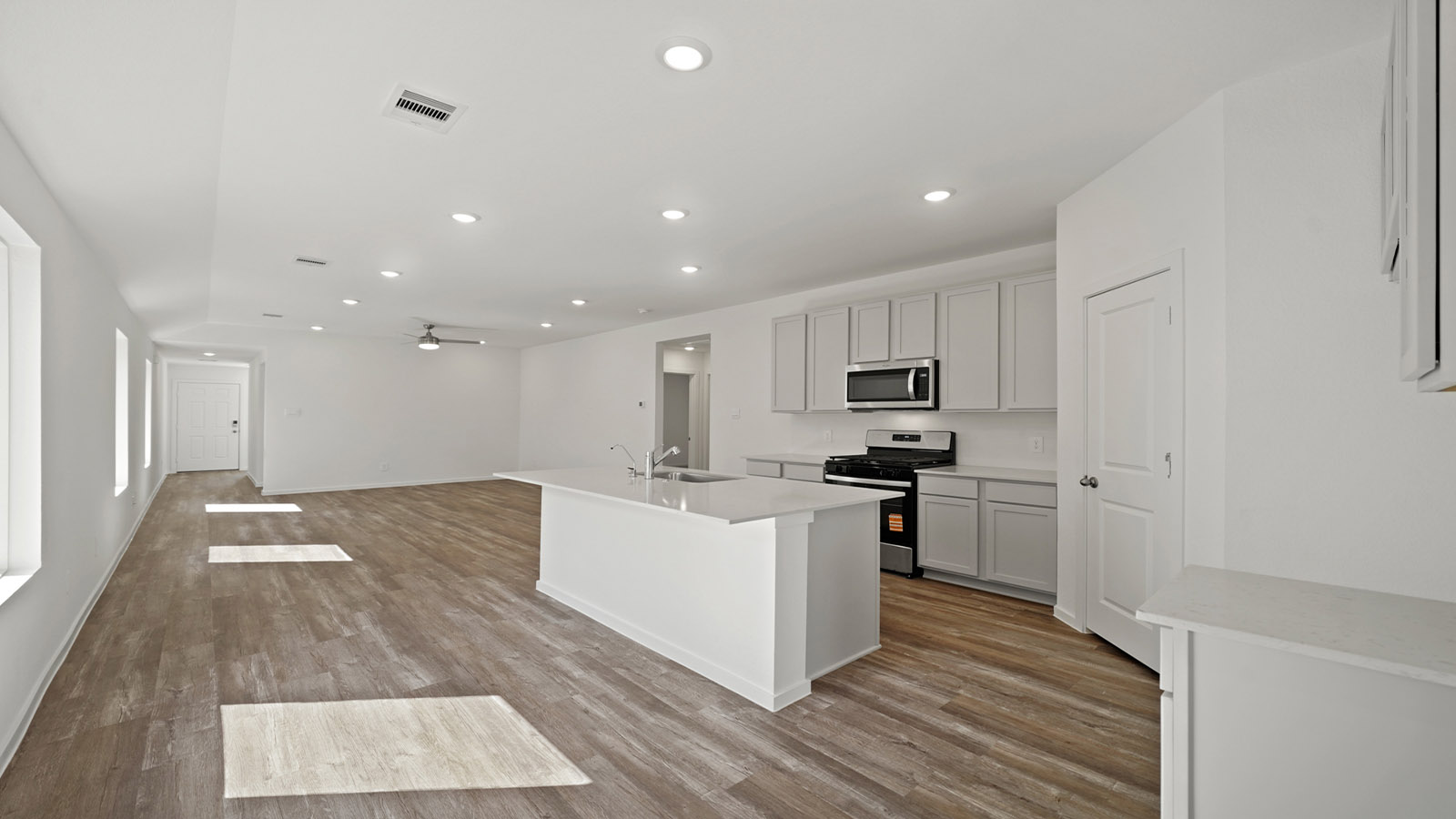 open concept living and dining area with vinyl flooring, quartz countertops, and large windows