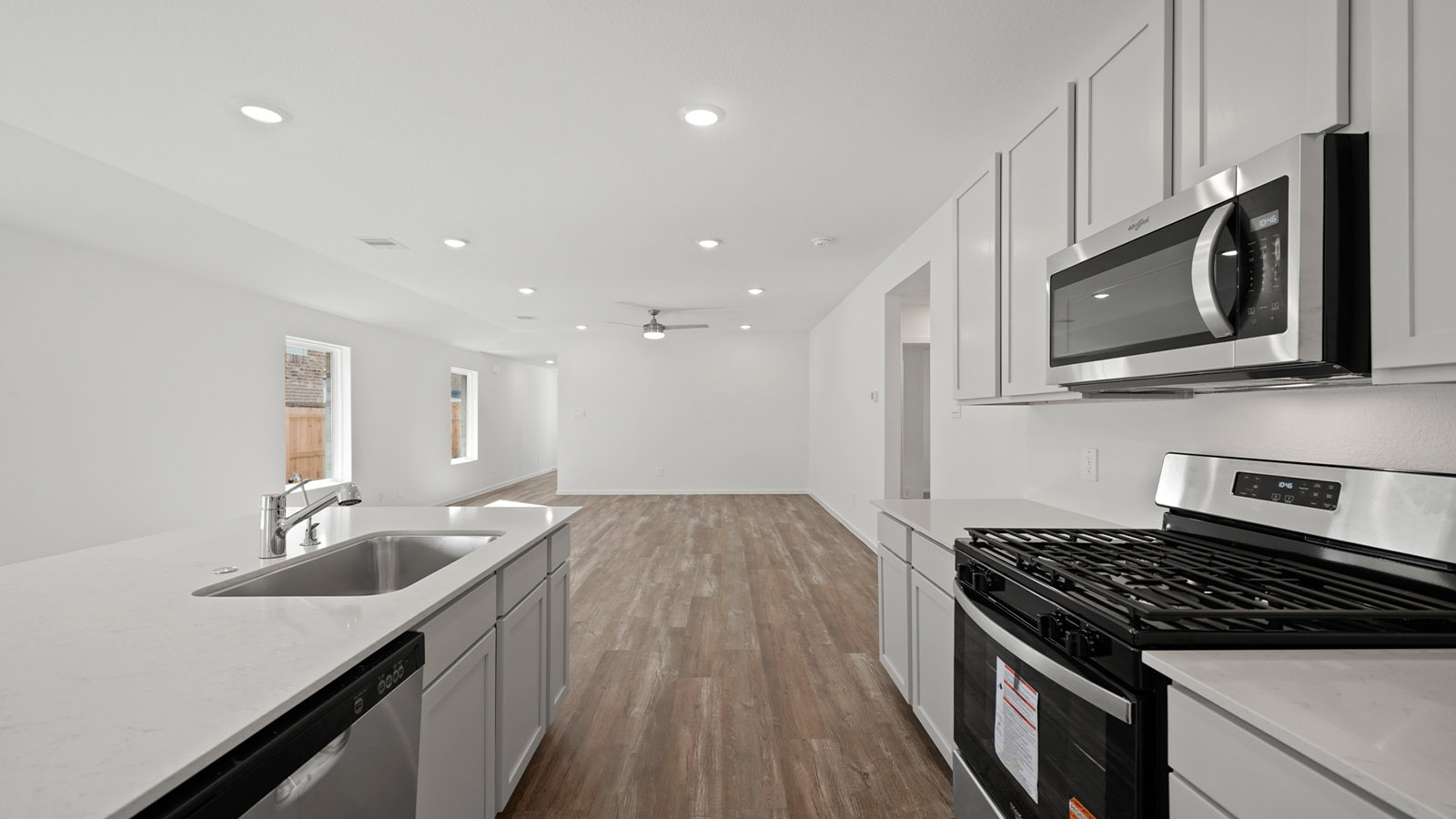 open concept living and dining area with vinyl flooring, quartz countertops, and large windows