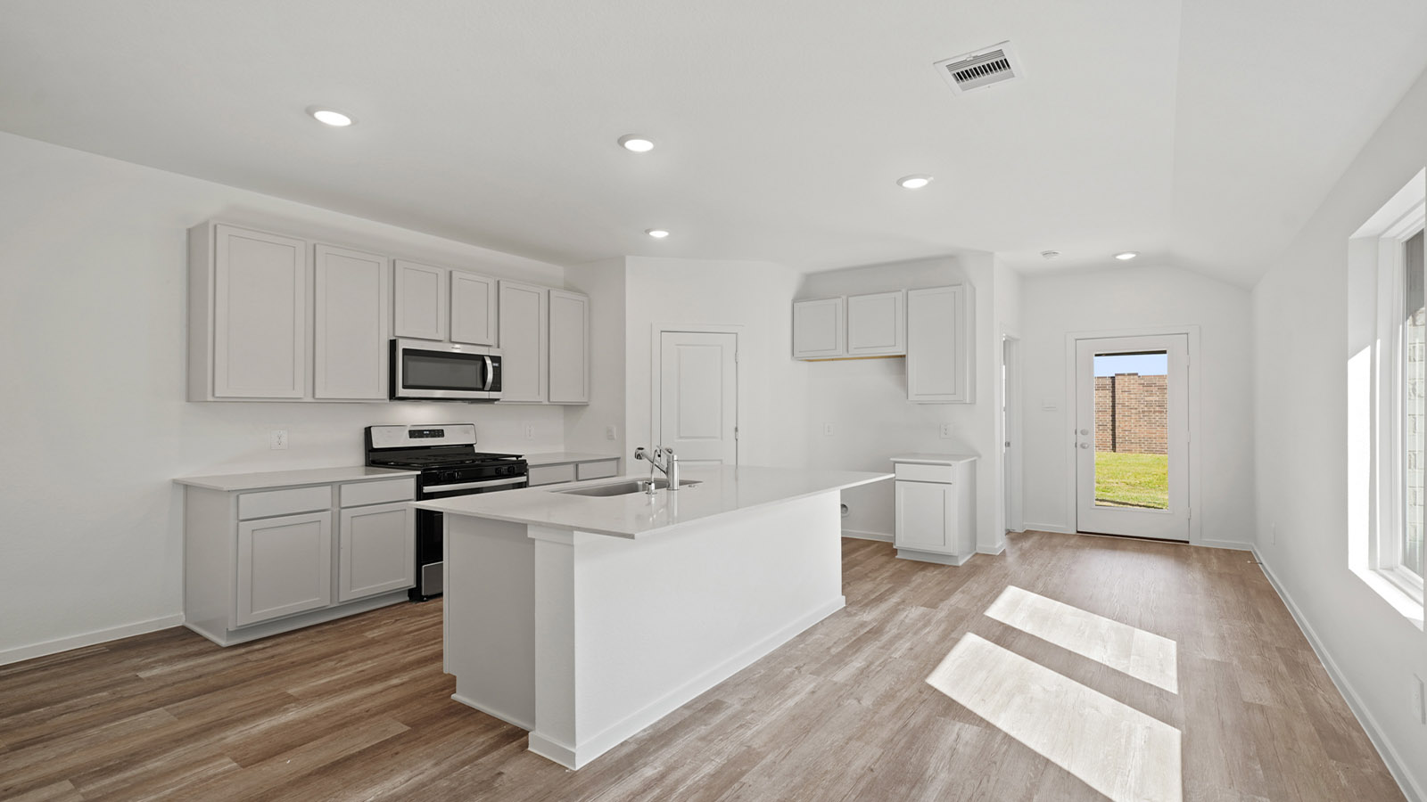 open concept living and dining area with vinyl flooring, quartz countertops, and large windows