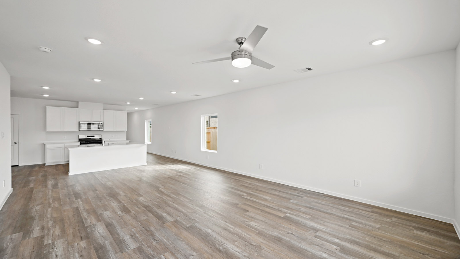 open concept living and dingin area with vinyl flooring, quartz countertops, and stainless steel appliances