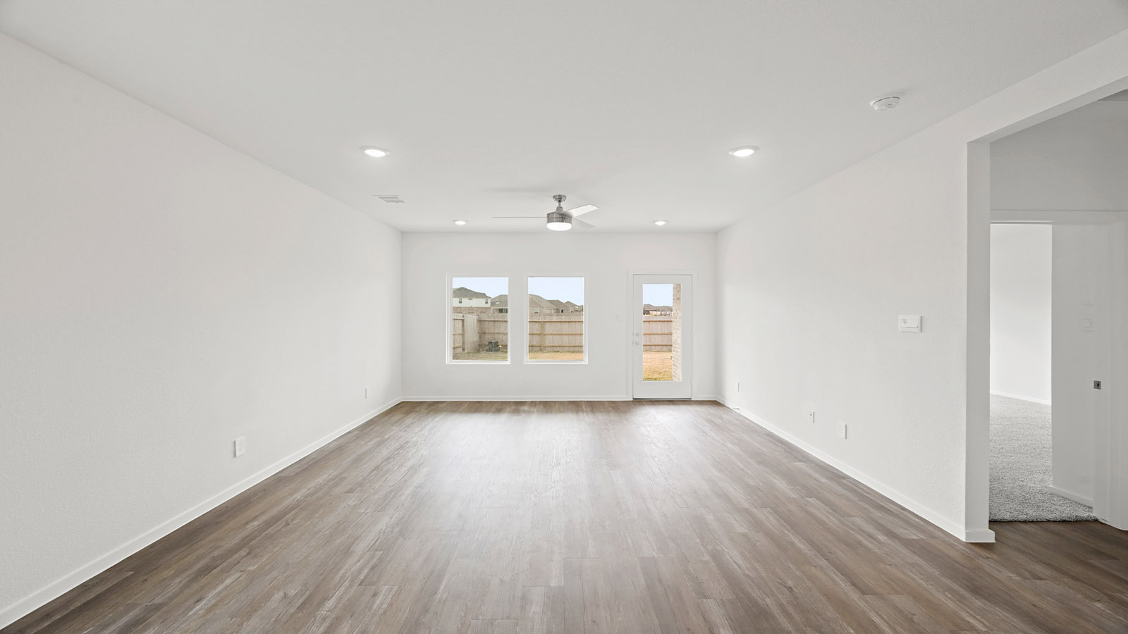 open concept living and dingin area with vinyl flooring, quartz countertops, and stainless steel appliances