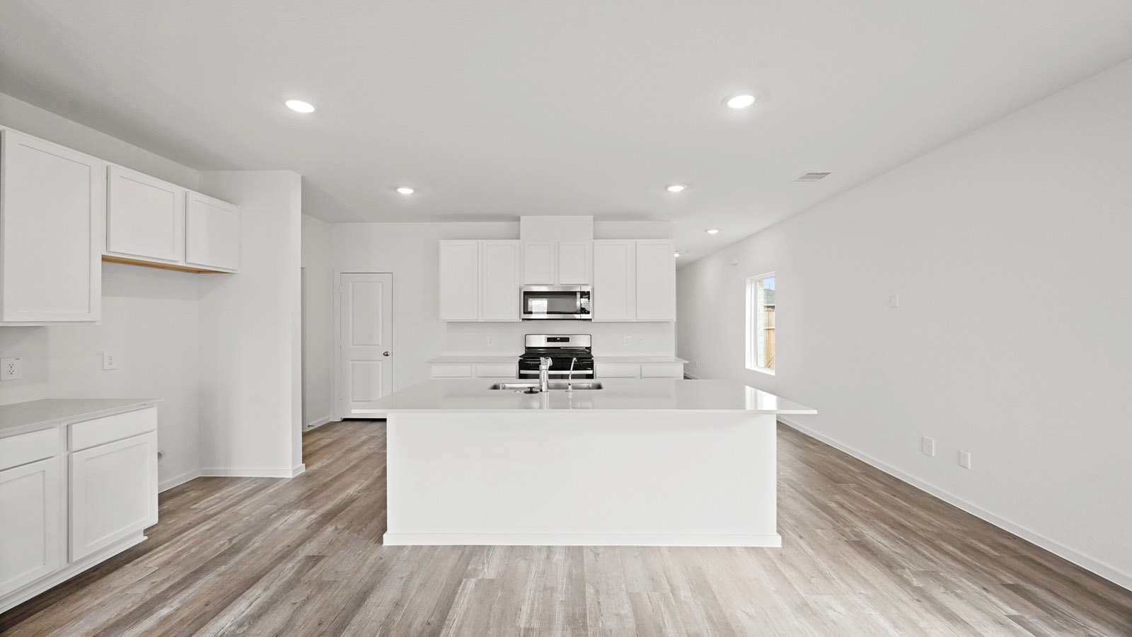 open concept living and dingin area with vinyl flooring, quartz countertops, and stainless steel appliances