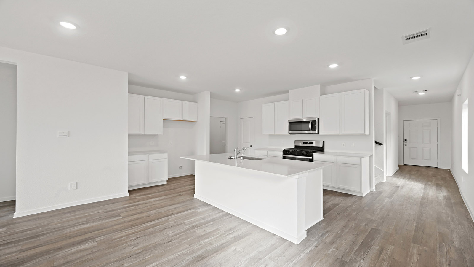 open concept living and dingin area with vinyl flooring, quartz countertops, and stainless steel appliances