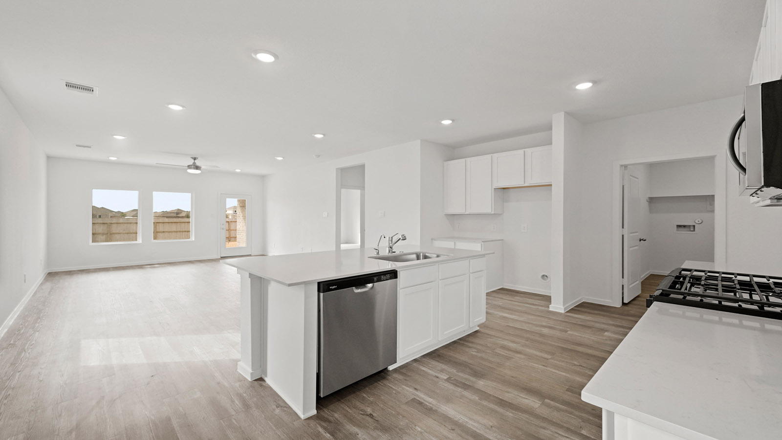 open concept living and dingin area with vinyl flooring, quartz countertops, and stainless steel appliances