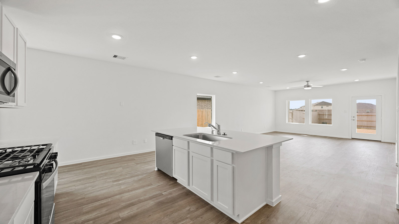 open concept living and dingin area with vinyl flooring, quartz countertops, and stainless steel appliances