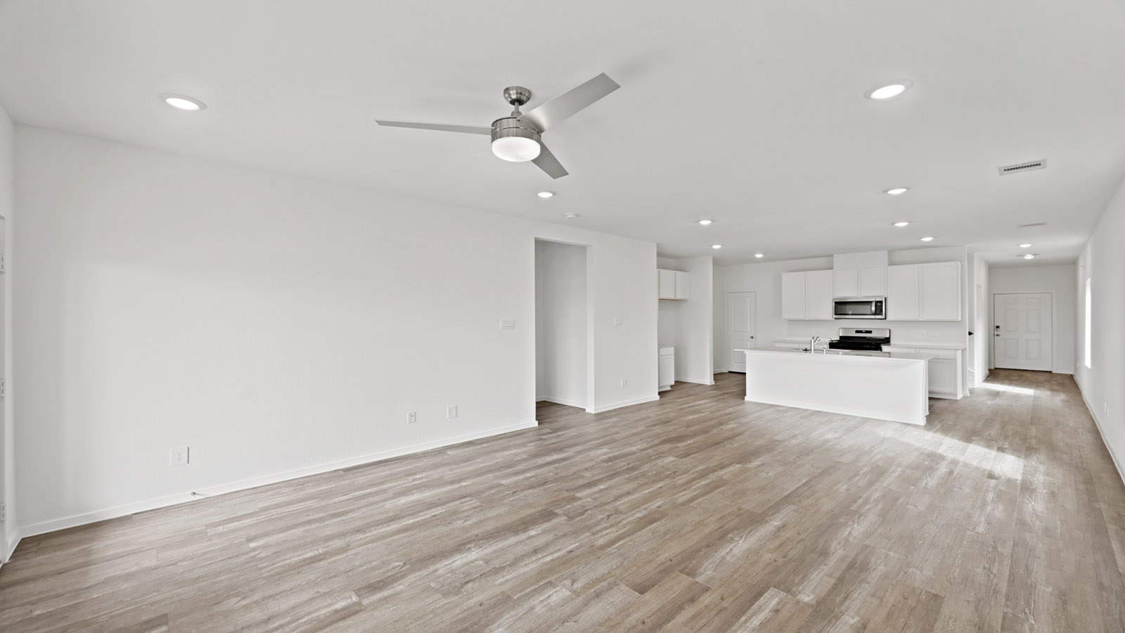 open concept living and dingin area with vinyl flooring, quartz countertops, and stainless steel appliances