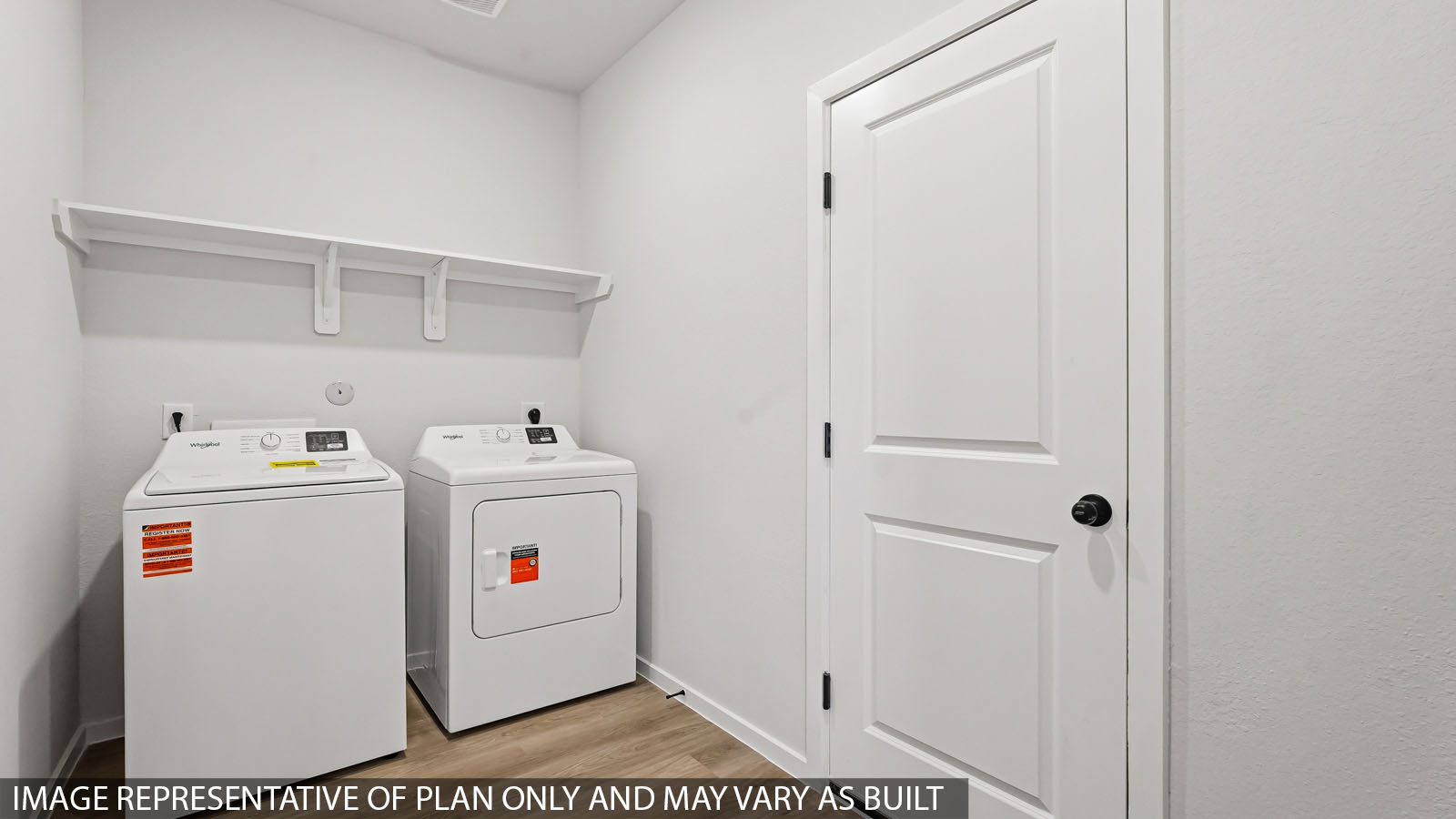 Laundry room with white walls and vinyl wood flooring.