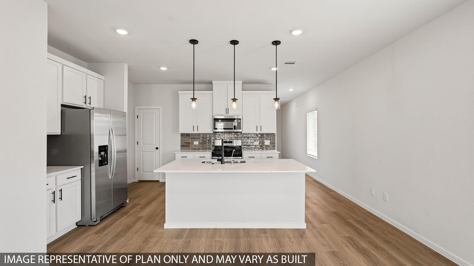 Open kitchen with an island, stainless steel appliances, white cabinets, white walls, and vinyl wood flooring.