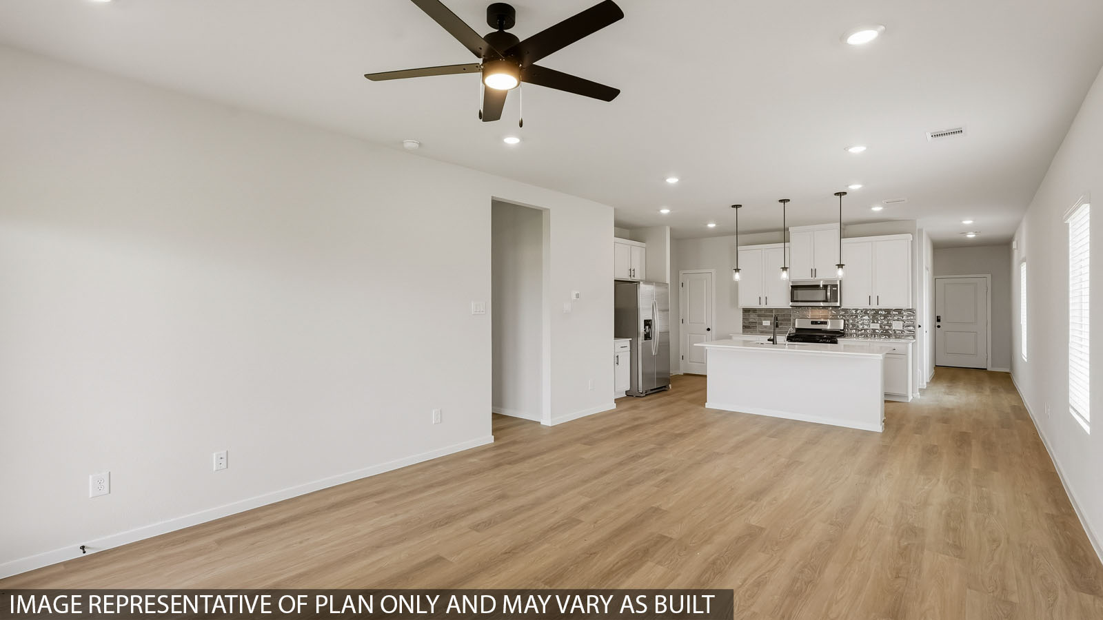 Open living room with windows, white walls, and vinyl wood flooring.
