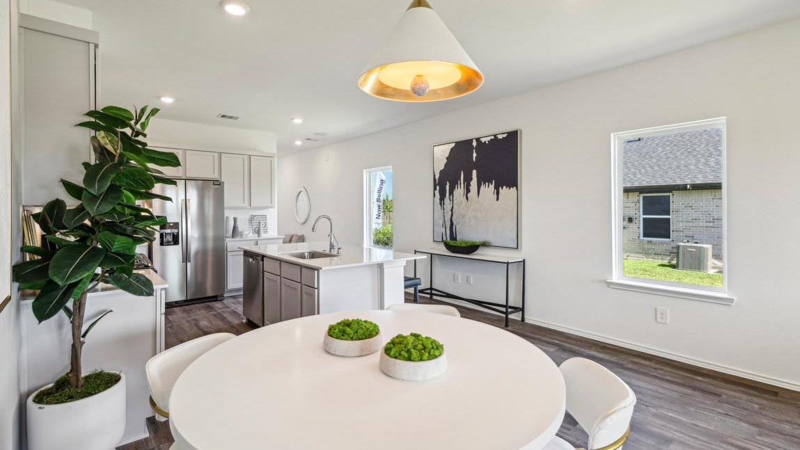 open concept living and dining area with vinyl flooring, quartz countertops, and large windows
