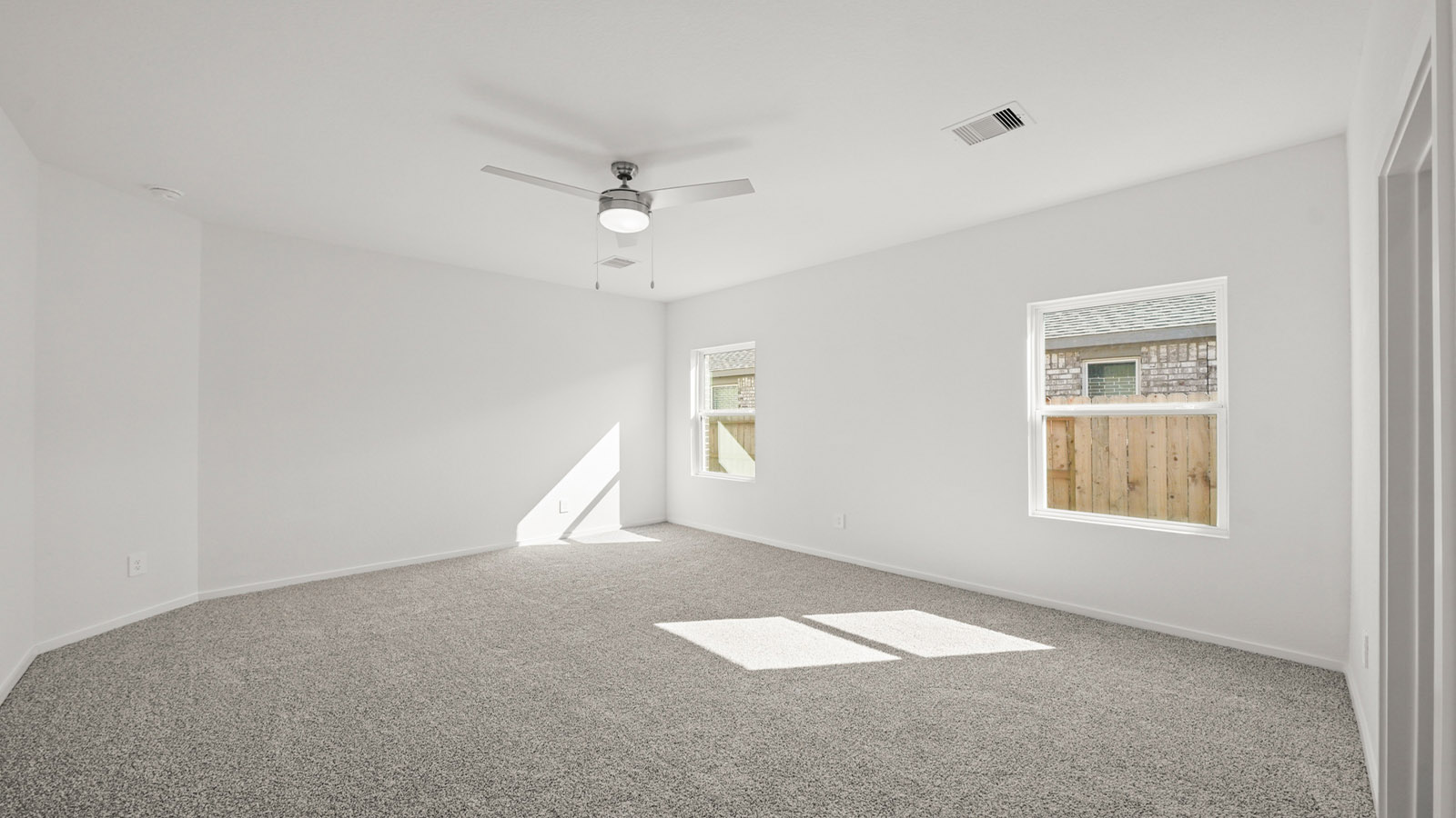 Primary bedroom features ample space, double windows, soft carpet, a stylish walk-in closet, and a private ensuite bath
