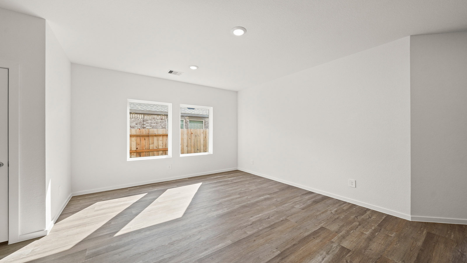 open concept living and dining room with large windows and vinyl flooring
