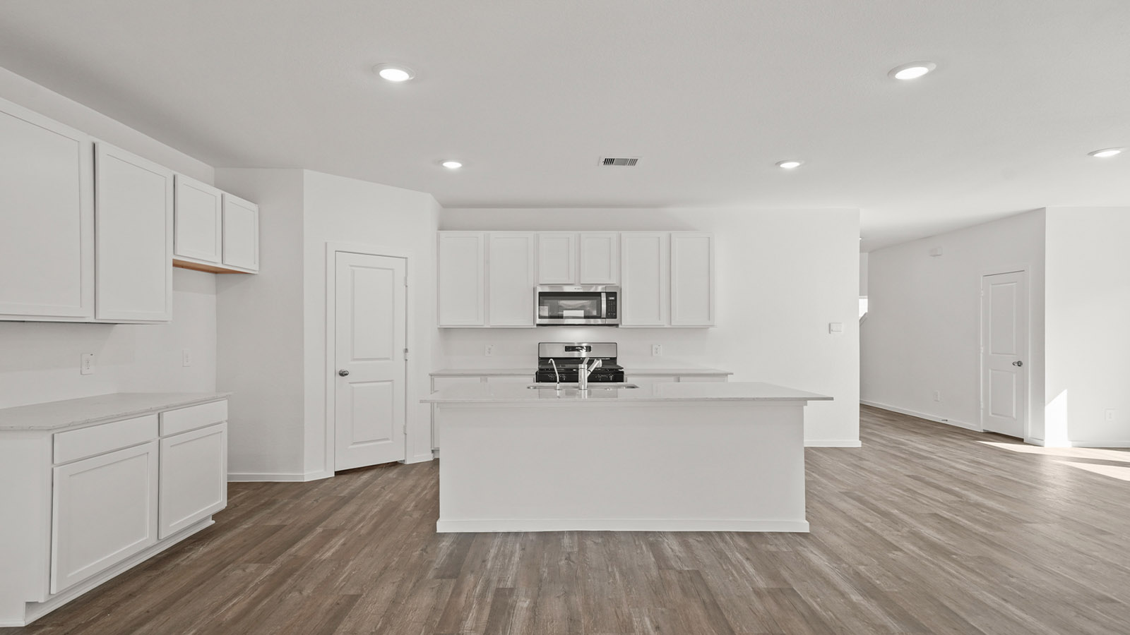 Central kitchen island anchors the home adding a dining option, full sink, pantry and storage, multi-prep zones