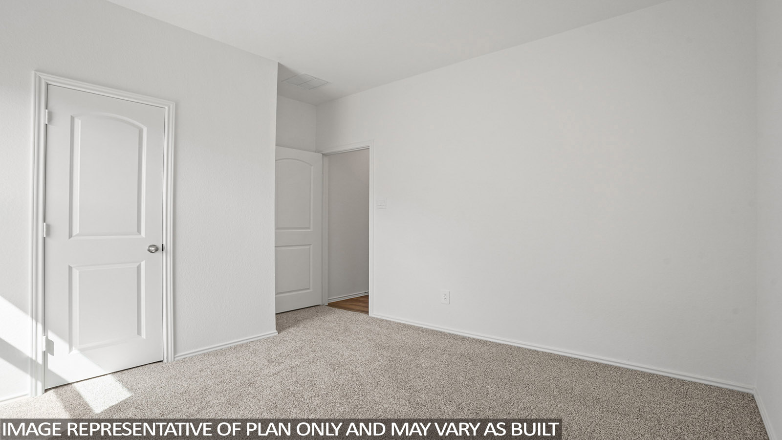 Secondary bedroom with windows, white walls, and light carpet.