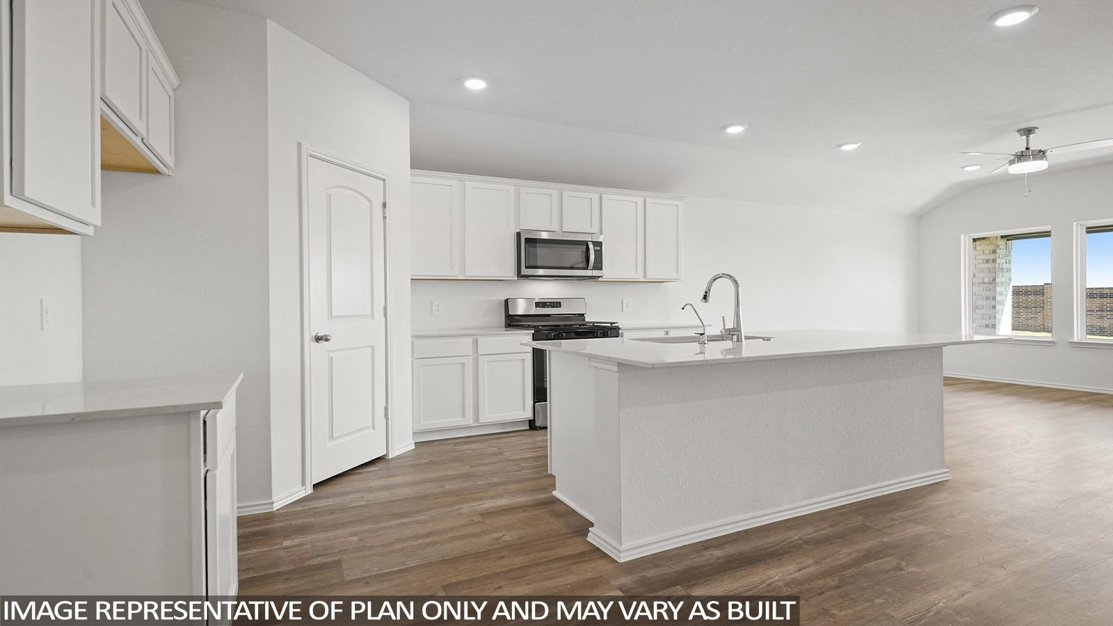 Open kitchen with an island, stainless steel appliances, white cabinets, white walls, and vinyl wood flooring.
