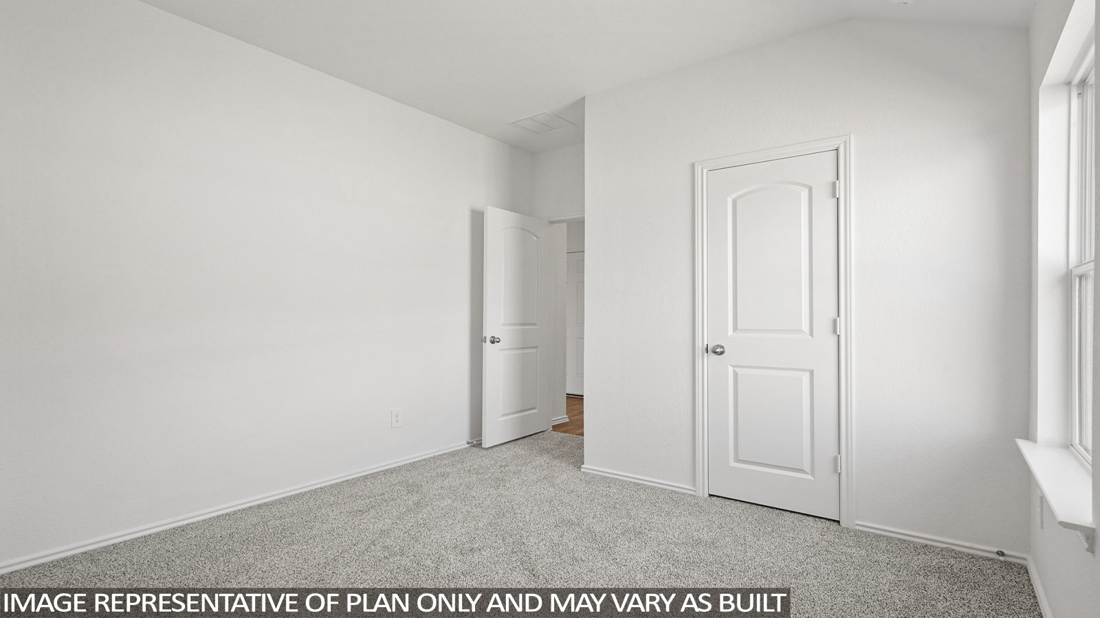 Secondary bedroom with windows, white walls, and light carpet.