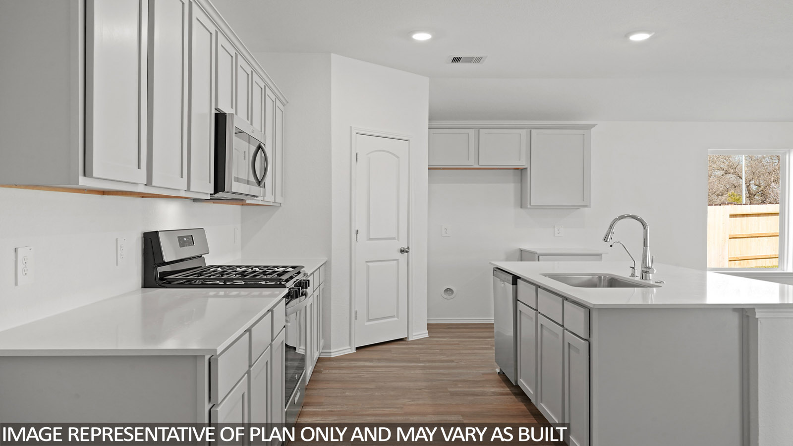 Open kitchen with an island, stainless steel appliances, white cabinets, white walls, and vinyl wood flooring.