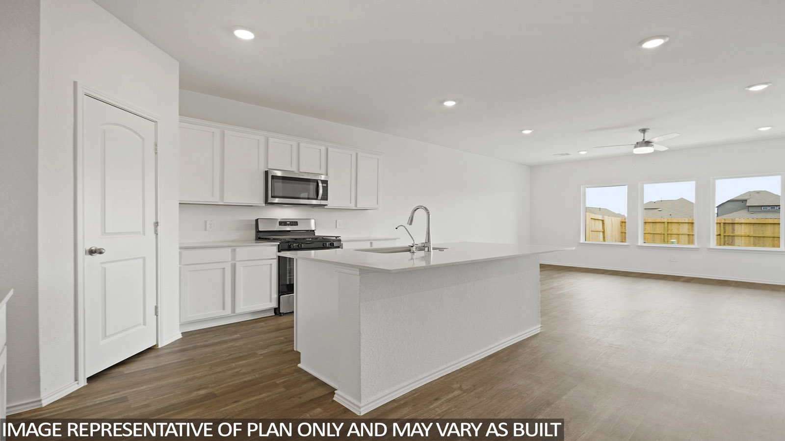 Open kitchen with an island, stainless steel appliances, white cabinets, white walls, and vinyl wood flooring.