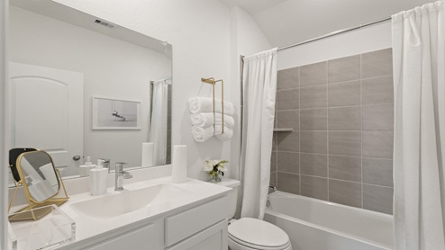 Secondary bathroom with a shower and tub combo, white walls, and vinyl wood flooring.