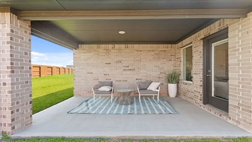 Landscaped backyard with a covered patio.