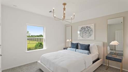 Secondary bedroom with windows, white walls, and light carpet.