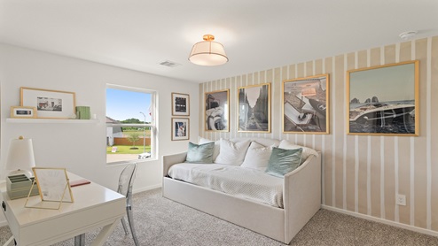Secondary bedroom with windows, white walls, and light carpet.