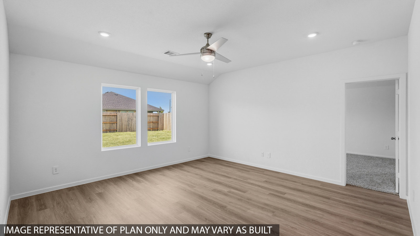 Open living room with white walls, windows, and vinyl wood flooring.