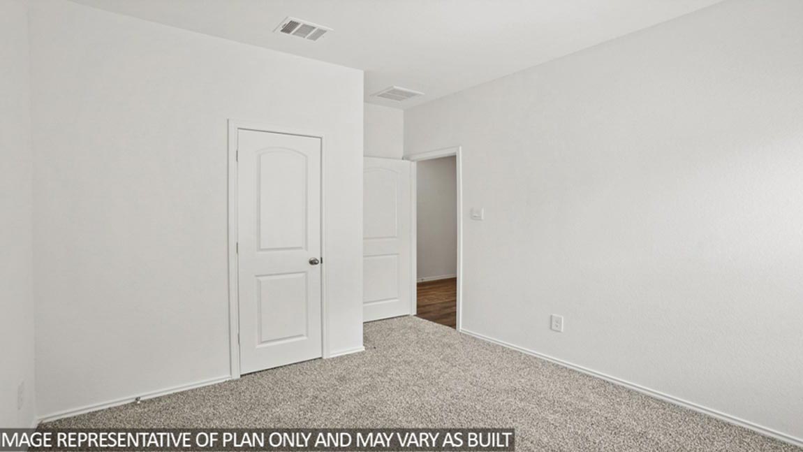 Secondary bedroom with white walls, windows, and light carpet.