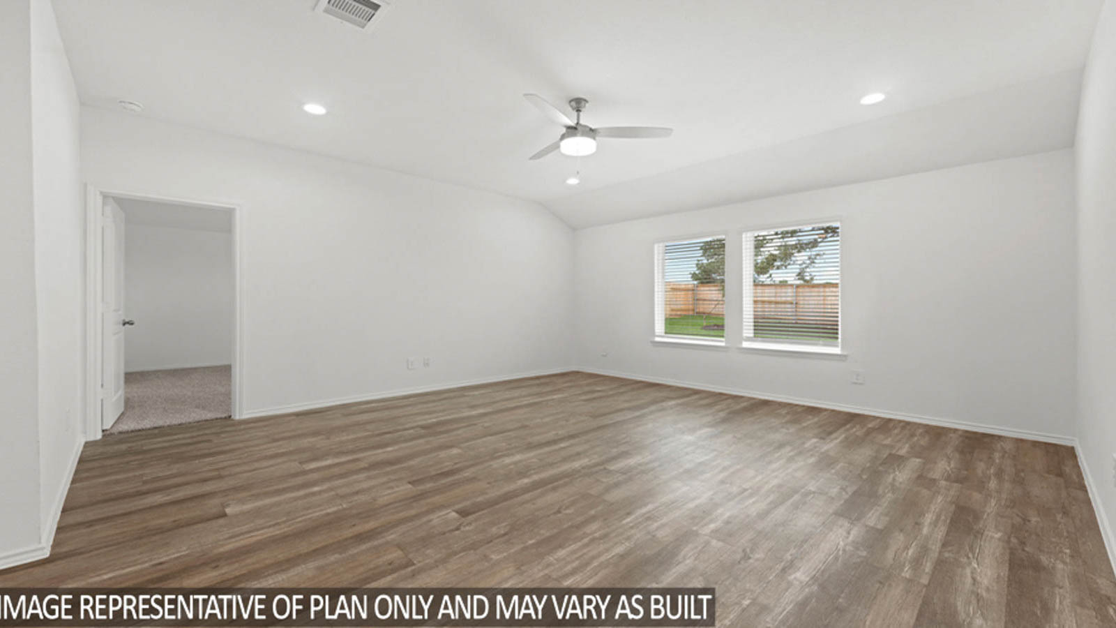 Open living room with white walls, windows, and vinyl wood flooring.