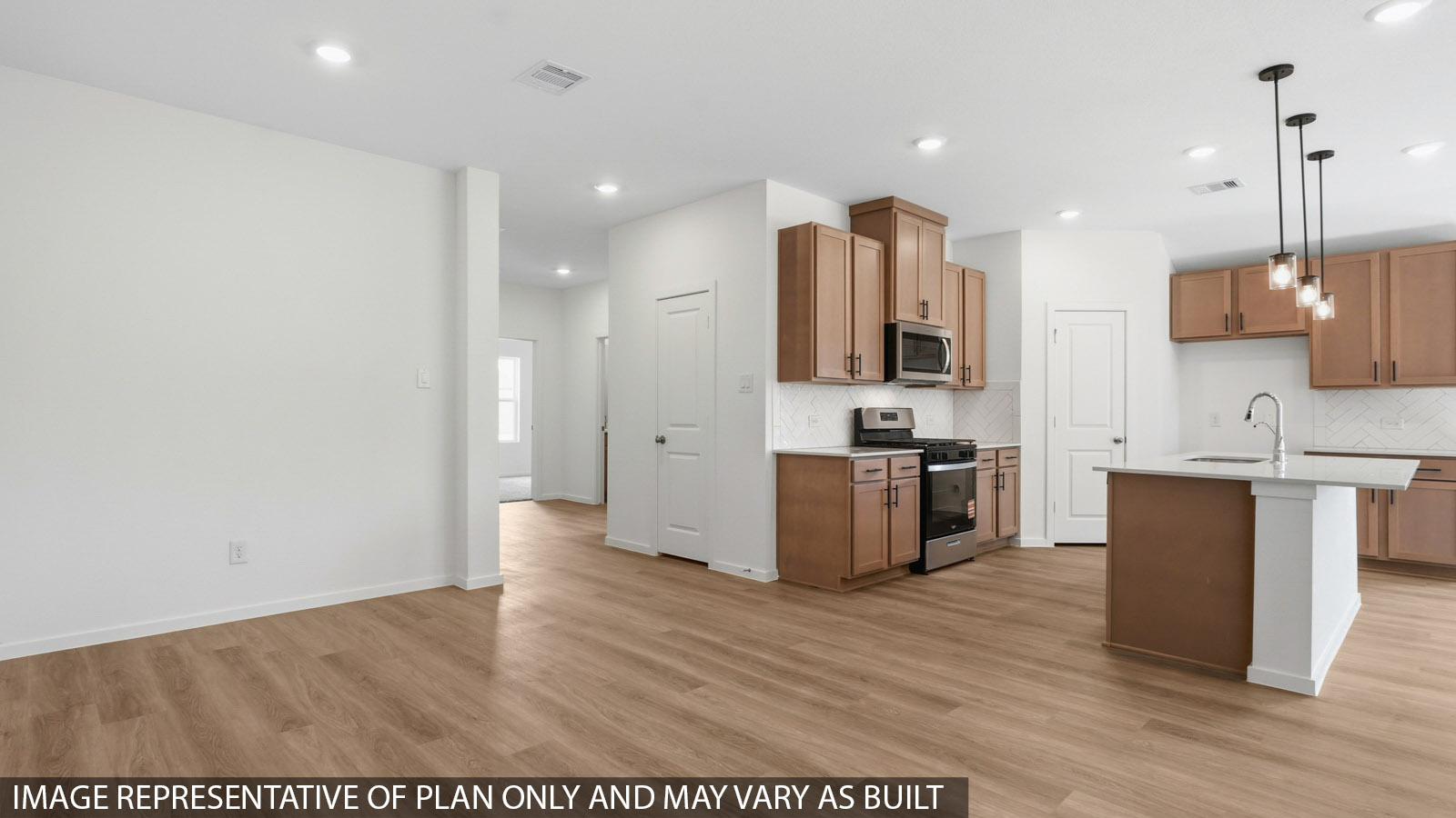 Open kitchen with an island, stainless steel appliances, white cabinets, white walls, and vinyl wood flooring.