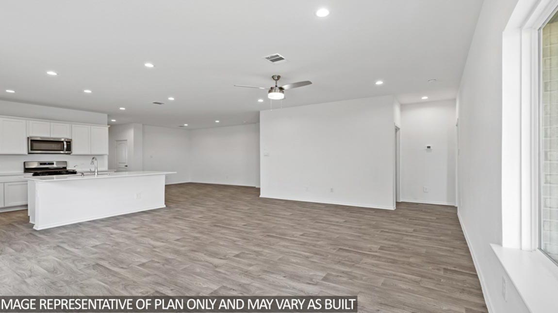Open living room with white walls, windows, and vinyl wood flooring.