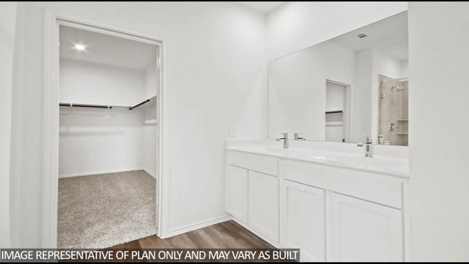 Primary bathroom with a shower, tub, dual sinks, white cabinets, white walls, and vinyl wood flooring.