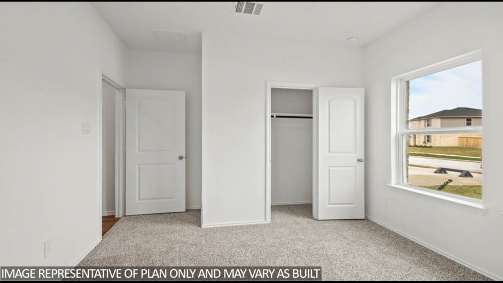 Secondary bedroom with white walls, windows, and light carpet.