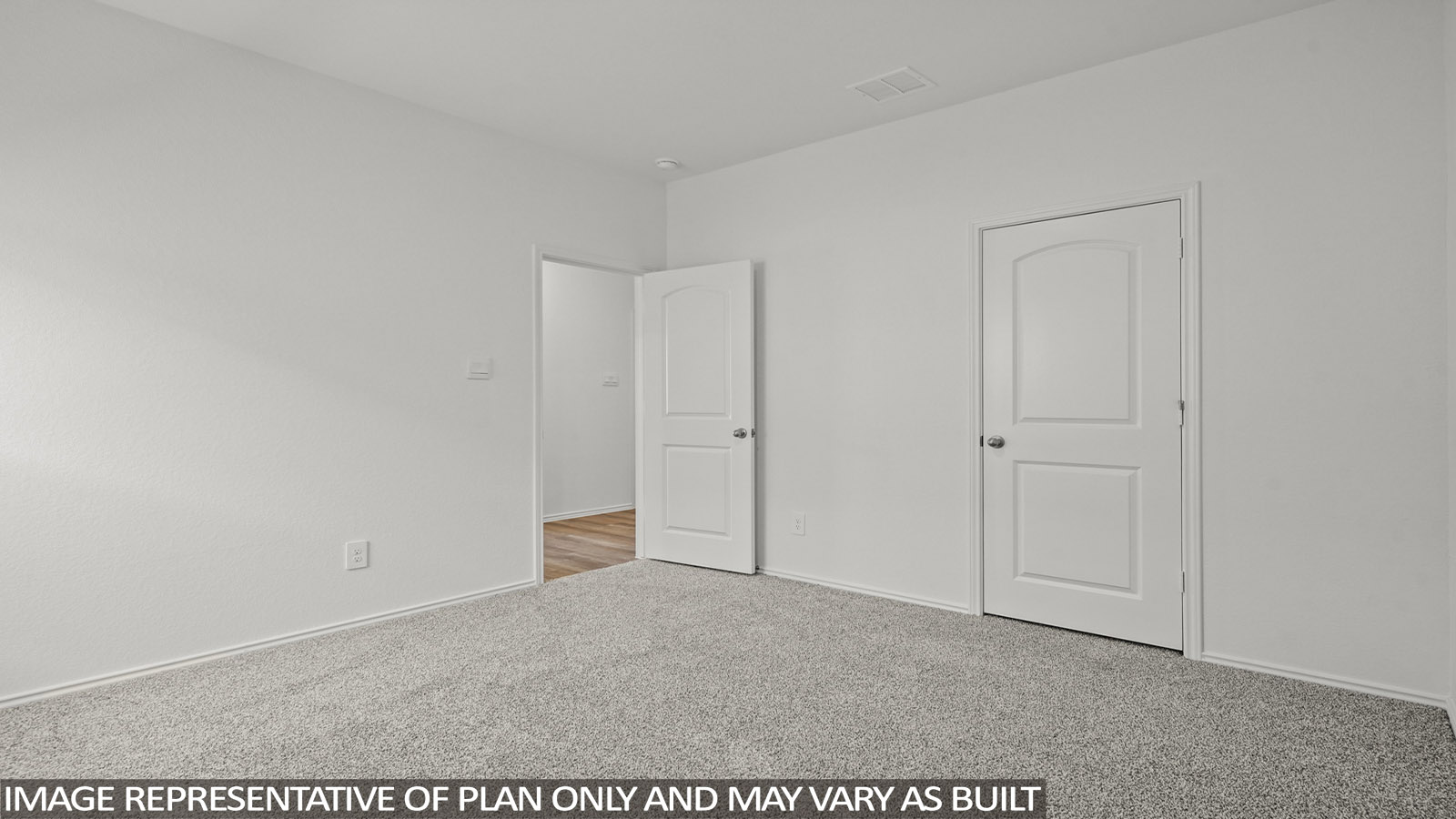 Secondary bedroom with windows, white walls, and light carpet.