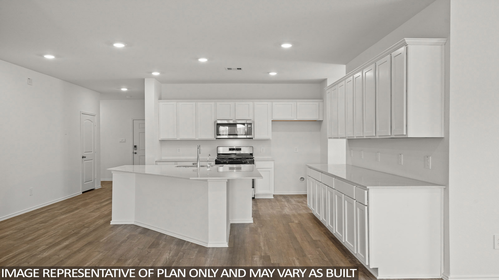 Open kitchen with an island, stainless steel appliances, white cabinets, whtie walls, and vinyl wood flooring.