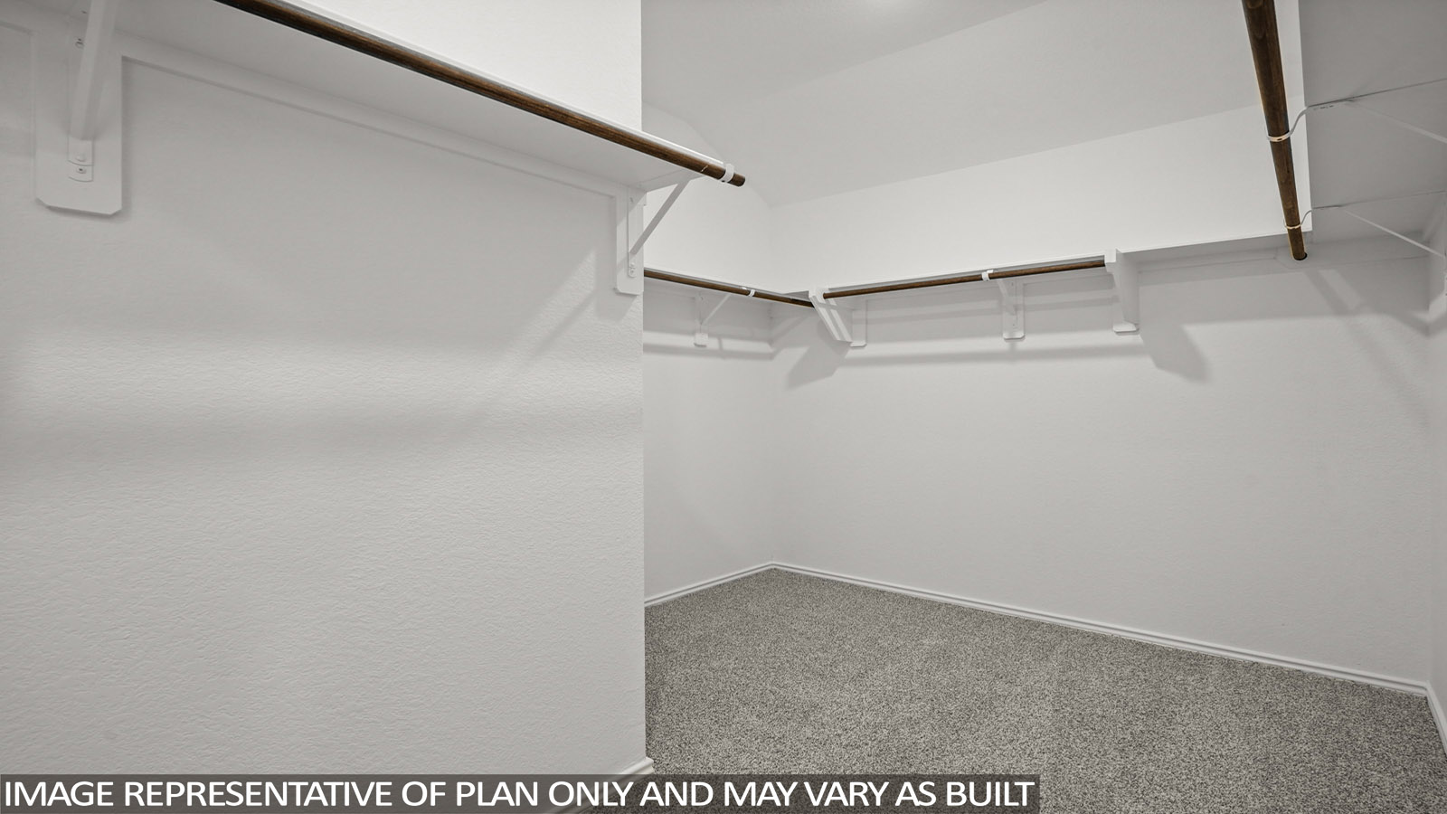 Primary closet with white walls and light carpet.