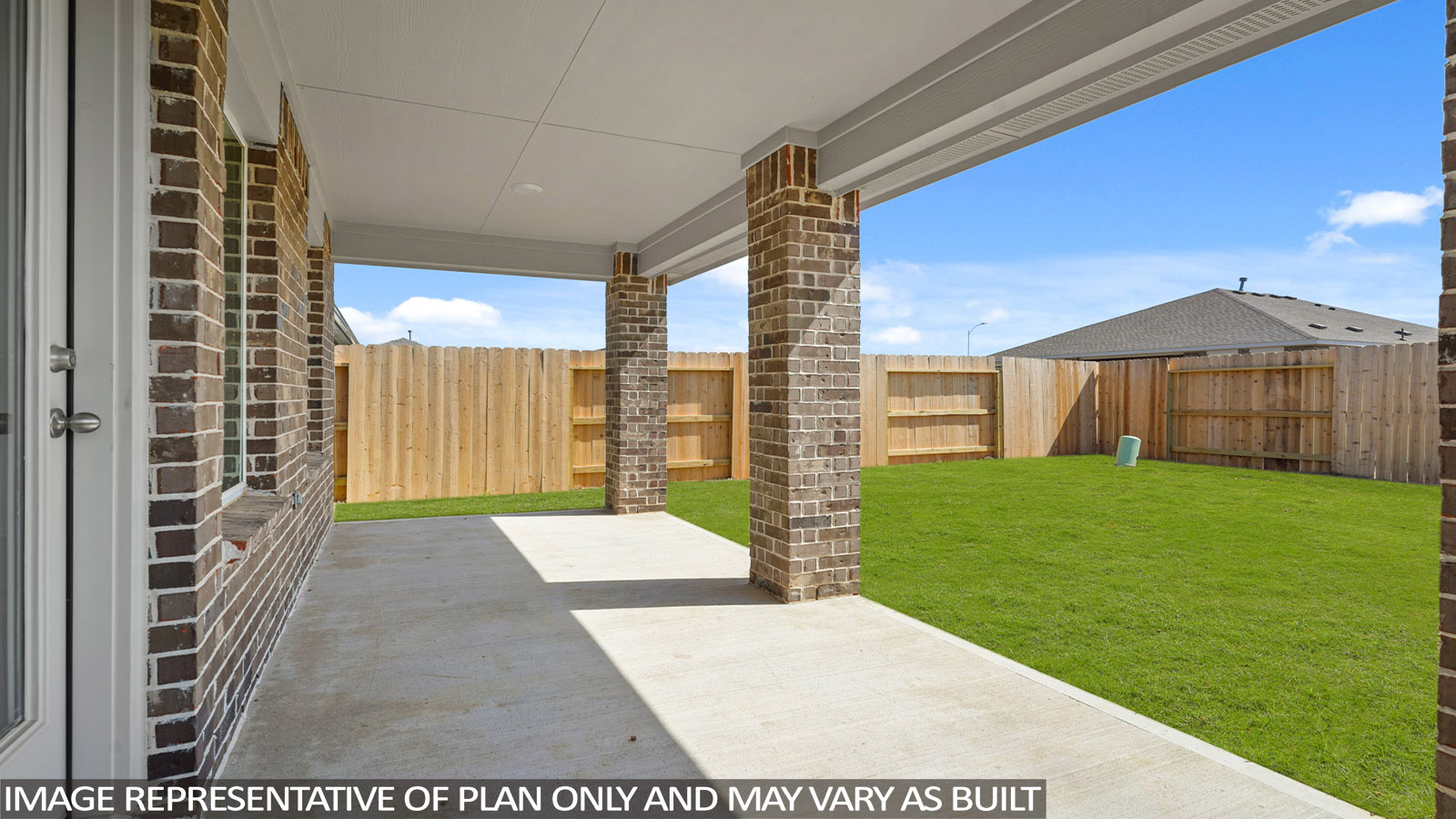 Landscaped backyard with a covered patio.