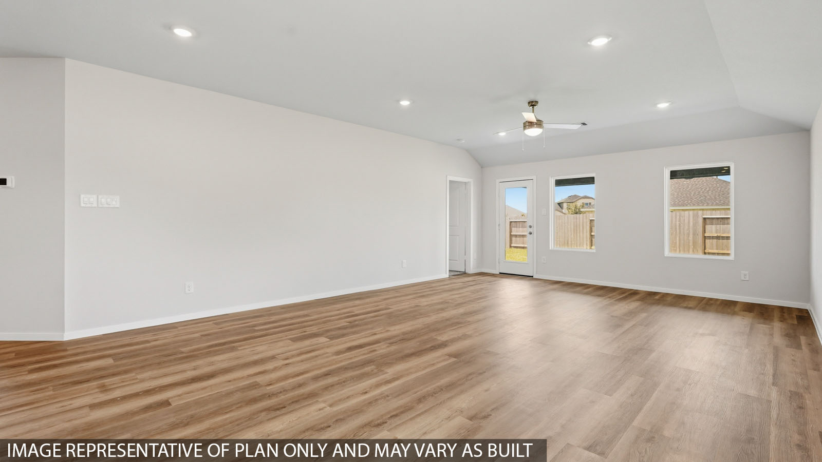 Open living room with windows, white walls, and vinyl wood flooring.