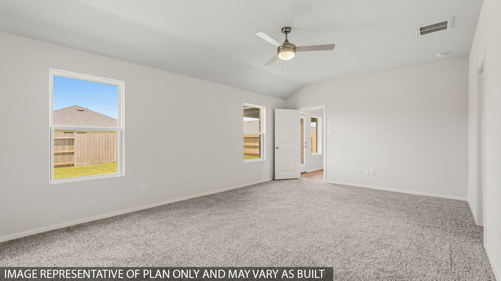 Primary bedroom with windows, white walls, and light carpet.