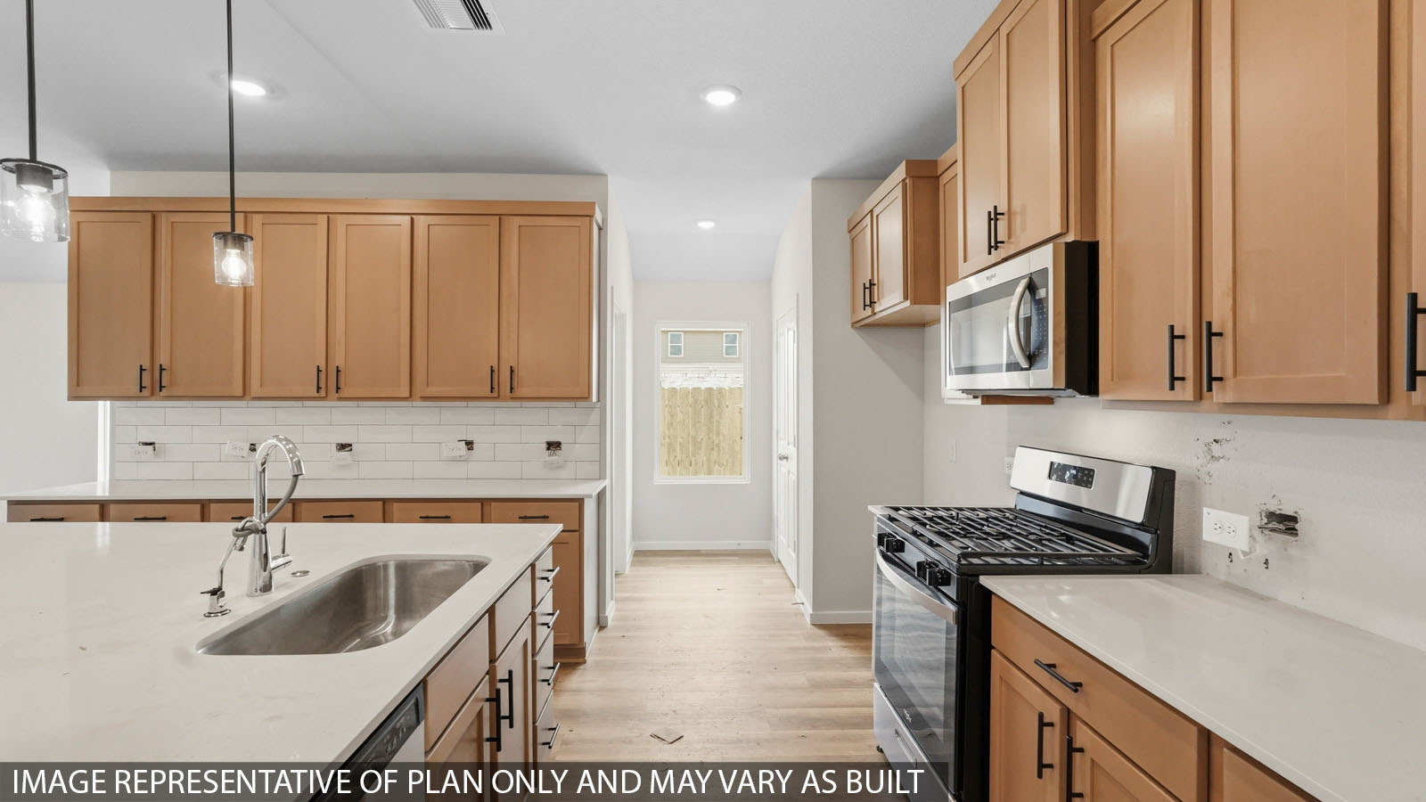 Open kitchen with an island, stainless steel appliances, white cabinets, whtie walls, and vinyl wood flooring.