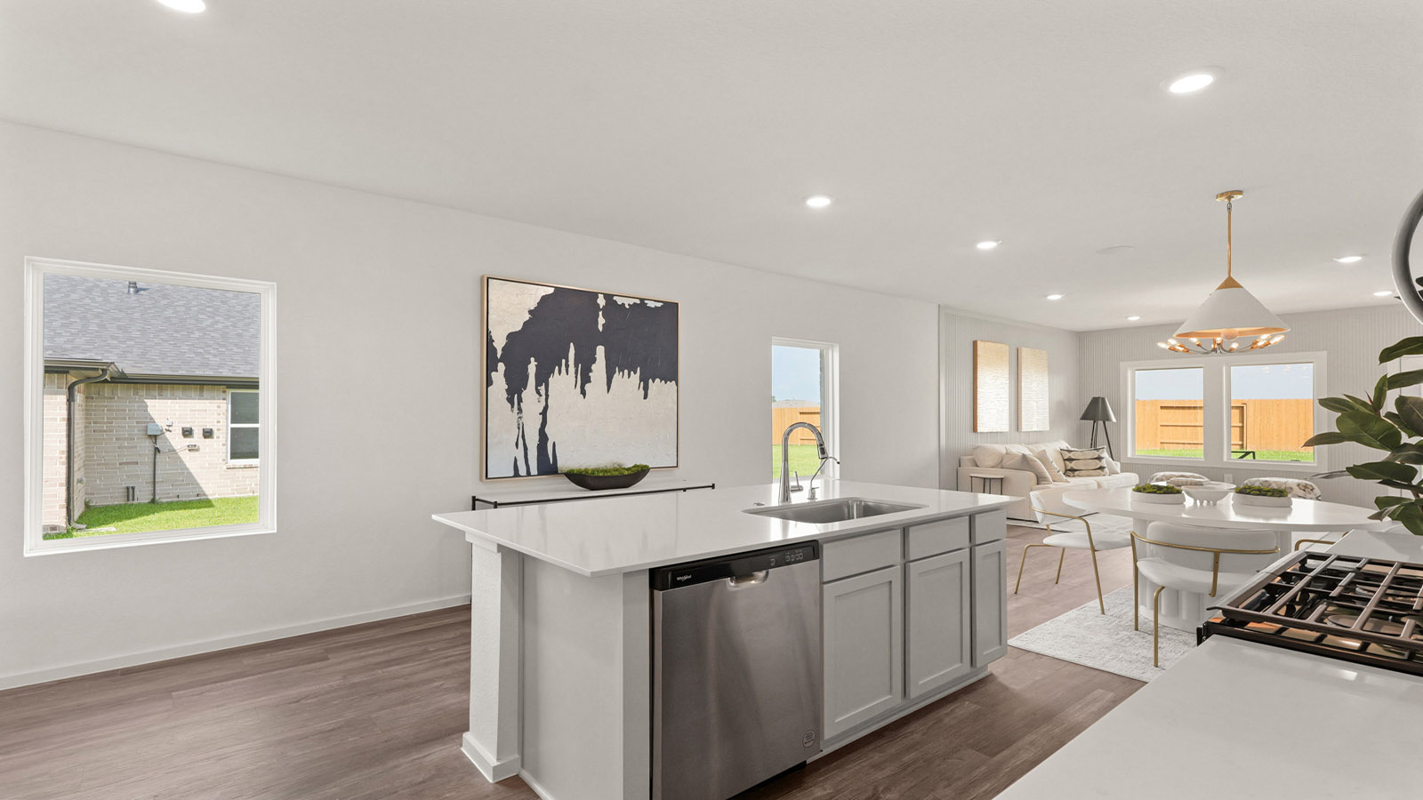 open concept living and dining area with vinyl flooring, quartz countertops, and large windows
