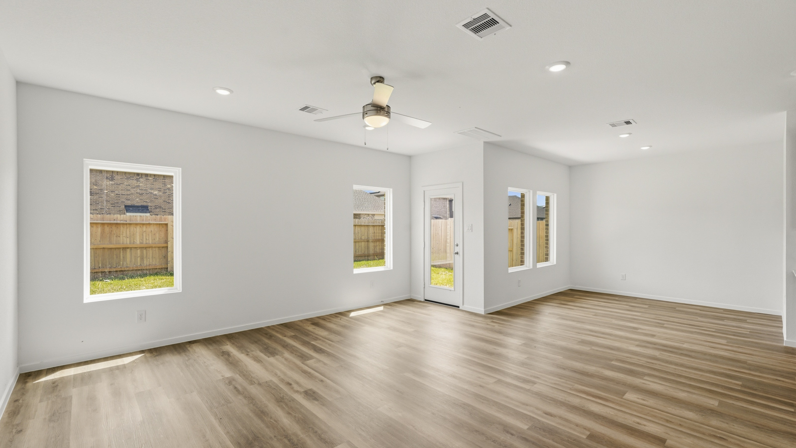 open concept living and dining area with quartz countertops, stainless steel appliances and vinyl flooring in Hockley, Tx