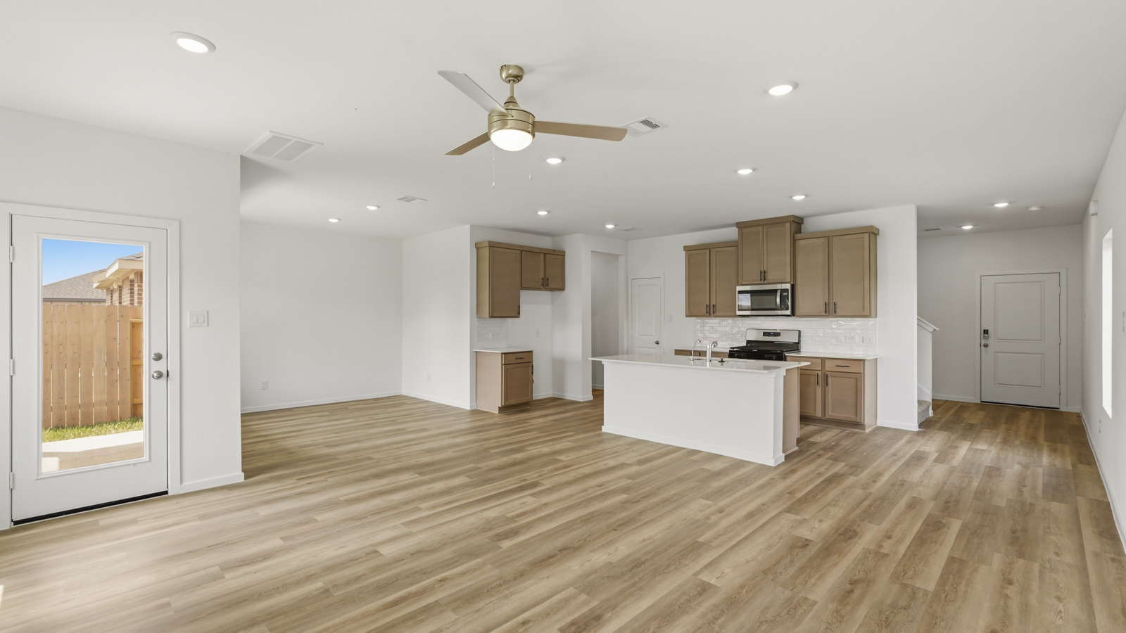 open concept living and dining area with quartz countertops, stainless steel appliances and vinyl flooring in Hockley, Tx